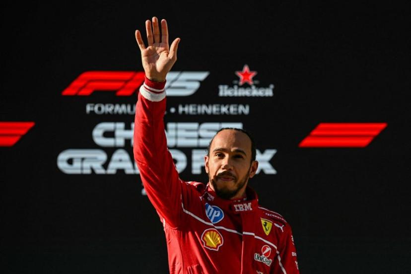 Ferrari's British driver Lewis Hamilton waves as he celebrates taking pole position after the sprint qualifying session of the Formula One Chinese Grand Prix at the Shanghai International Circuit in Shanghai on March 21, 2025.  GREG BAKER / AFP