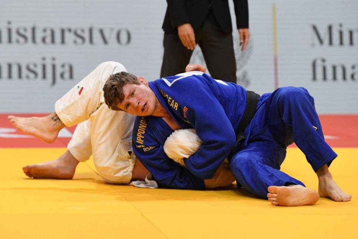 Belgium's Matthias Casse (blue) and Italy's Antonio Esposito (white) compete in the men's -81kg category during the European Championships judo in Podgorica, Montenegro, on April 25, 2025. The tournament is taking place from April 23 to 27, 2025.   SAVO PRELEVIC / AFP