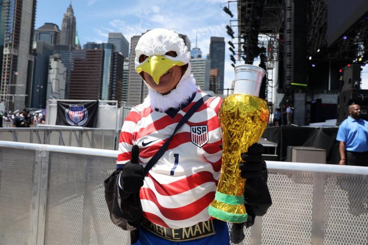 An attendee wearing an eagle mask poses holding an object made to resemble a FIFA World Cup trophy during the US Men's National Team 2026 World Cup roster announcement in New York, on May 26, 2026. TIMOTHY A. CLARY / AFP
