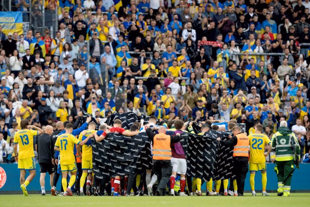 Denmark's and Ukraine's players huddle to accompany Denmark's midfielder #10 Christian Eriksen to a waiting ambulance during the football international friendly match between Denmark and Ukraine at Odense Stadium in Denmark, on June 7, 2026. Christian Eriksen collapsed during Denmark's friendly against Ukraine on June 7, 2026, five years after he suffered a cardiac arrest during the European Championships. Bo Amstrup / Ritzau Scanpix / AFP