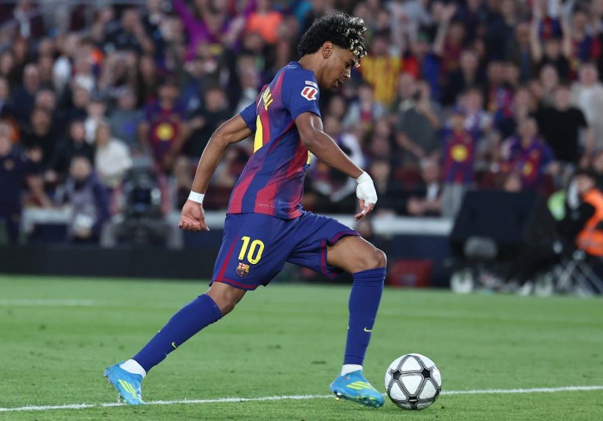 Barcelona's Spanish forward #10 Lamine Yamal scores his team's third goal during the Spanish league football match between FC Barcelona and RCD Espanyol at the Camp Nou stadium in Barcelona on April 11 , 2026. Josep LAGO / AFP