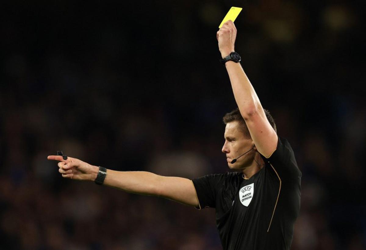 German referee Daniel Siebert shows a yellow card to Benfica's Argentinian defender #30 Nicolas Otamendi (unseen) during the UEFA Champions League, league phase football match between Chelsea and Benfica at Stamford Bridge in London on September 30, 2025. Adrian Dennis / AFP