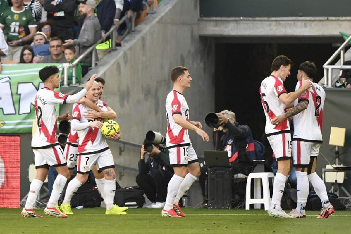 Rayo Vallecano's Spanish forward #07 Isi Palazon celebrates with teammates after scoring an equalizing goal during the Spanish league football match between Real Betis and Rayo Vallecano de Madrid at Benito Villamarin Stadium in Seville on February 21, 2026. CRISTINA QUICLER / AFP