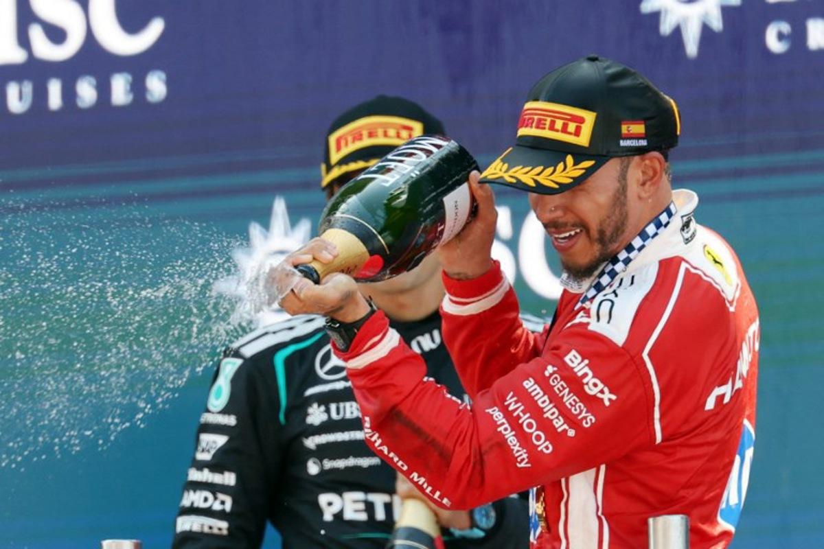 Winner Ferrari's British driver Lewis Hamilton (R) and second placed Mercedes' British driver George Russell celebrate in the podium after the Catalonia Formula One Grand Prix at the Circuit de Catalunya in Montmelo, on the outskirts of Barcelona, on June 14, 2026. Lluis GENE / AFP