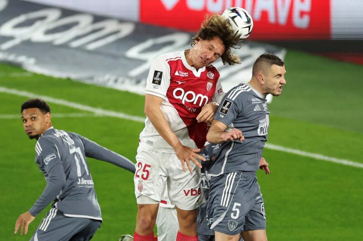Monaco's Belgian defender #25 Wout Faes (C) fights for the ball with Brest's French defender #05 Brendan Chardonnet (R) during the French L1 football match between AS Monaco and Stade Brestois 29 at the Stade Louis II in the Principality of Monaco on March 14, 2026. Valery HACHE / AFP