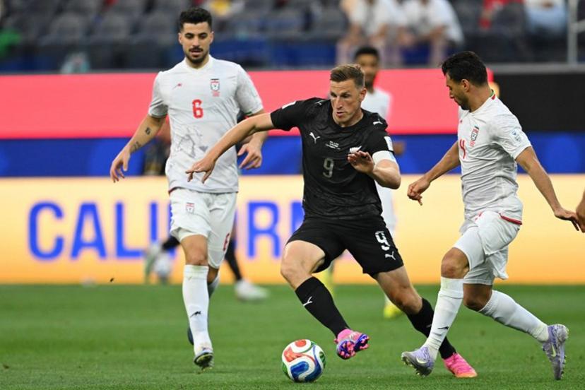 New Zealand's forward #09 Chris Wood runs with the ball past Iran's defender #04 Shojae Khalilzadeh during the 2026 World Cup Group G football match between Iran and New Zealand at Los Angeles Stadium in Inglewood on June 15, 2026. Patrick T. Fallon / AFP