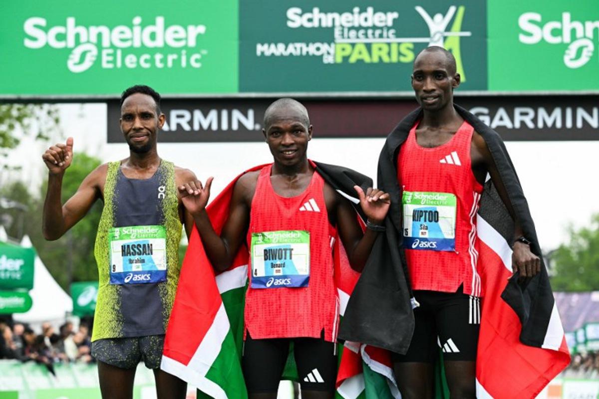 (From L) Second-placed Djibouti's Ibrahim Hassan, winner Kenya's Benard Biwott and third-placed Kenya's Sila Kiptoo pose after crossing the finish line in the men's Paris Marathon, in Paris, on April 13, 2025. Bertrand GUAY / AFP