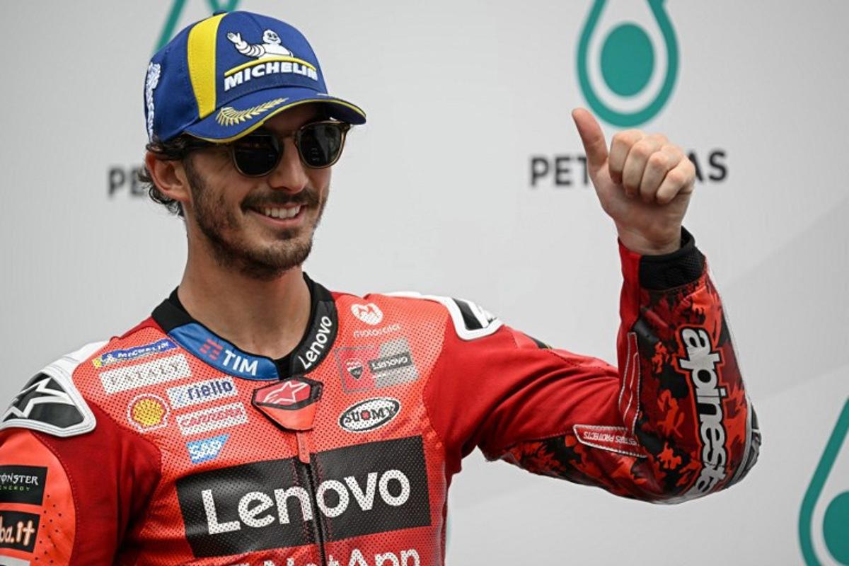 Ducati Lenovo Team's Italian MotoGP rider Francesco Bagnaia (C) celebrates coming first in the qualifying session of the MotoGP Malaysian Grand Prix at the Sepang International Circuit in Sepang on October 25, 2025. Lillian SUWANRUMPHA / AFP