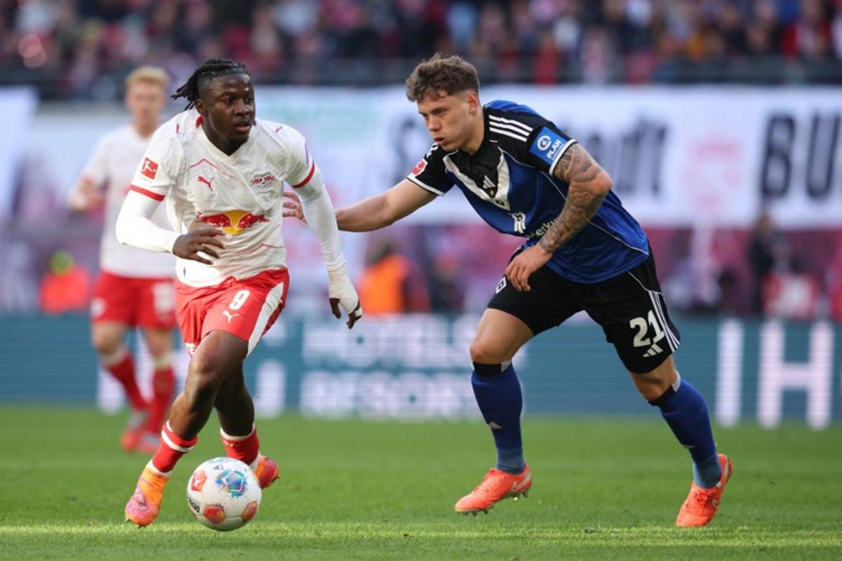 Leipzig's Belgian forward #09 Johan Bakayoko (L) and Hamburg's German midfielder #21 Nicolai Remberg vie for the ball during the German first division Bundesliga football match RB Leipzig v Hamburg SV in Leipzig, eastern Germany on October 18, 2025. Ronny HARTMANN / AFP
