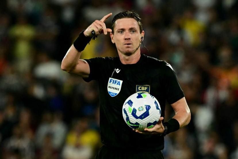 Brazilian referee Ramon Abatti gestures while holding the ball during the Brasileirao Seria A football match between Fluminense and Palmeiras at the Maracana Stadium in Rio de Janeiro, Brazil, on July 23, 2025. Pablo PORCIUNCULA / AFP