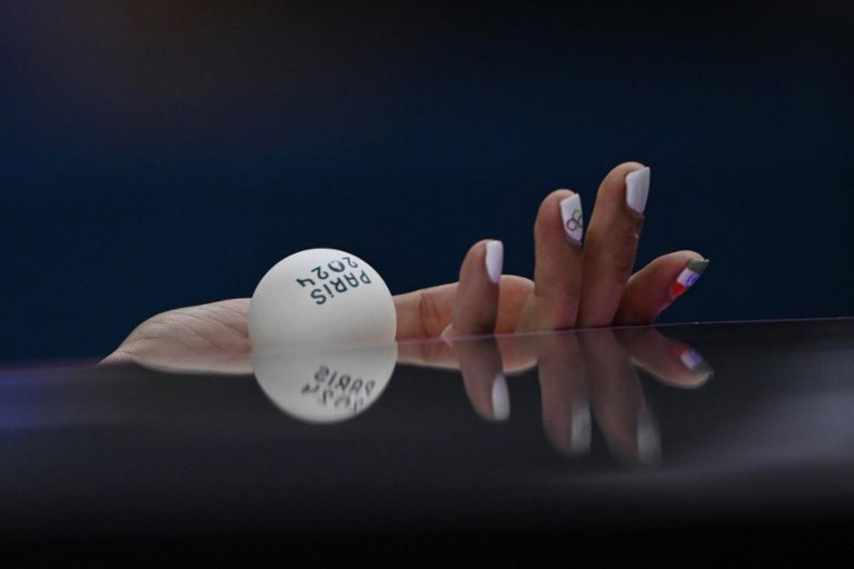 A detailed view of India's Manika Batra's nails painted with the Indian flag and Olympic Rings as she prepares to serve the ball during her women's table tennis singles match in the team quarter-finals between India and Germany at the Paris 2024 Olympic Games at the South Paris Arena in Paris on August 7, 2024. WANG Zhao / AFP