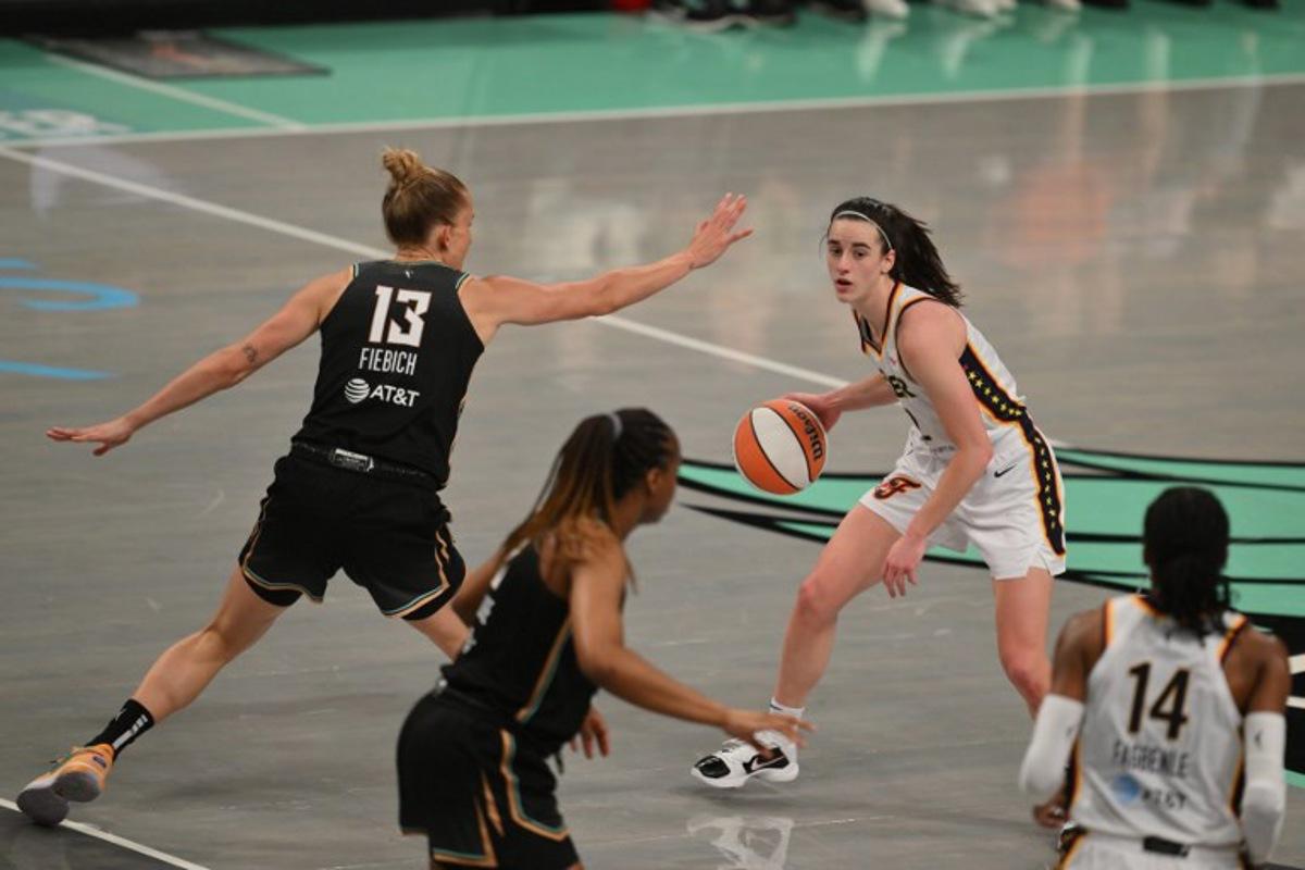 Indiana Fever guard #22 Caitlin Clark (R) dribbles the ball during a WNBA game between the Indiana Fever and New York Liberty, at the Barclays Center in Brooklyn on May 18, 2024, in New York City. ANGELA WEISS / AFP