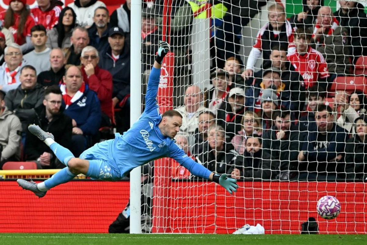Nottingham Forest's Belgian goalkeeper #26 Matz Sels reaches to save a shot during the English Premier League football match between Nottingham Forest and Chelsea at The City Ground in Nottingham, central England, on October 18, 2025. JUSTIN TALLIS / AFP