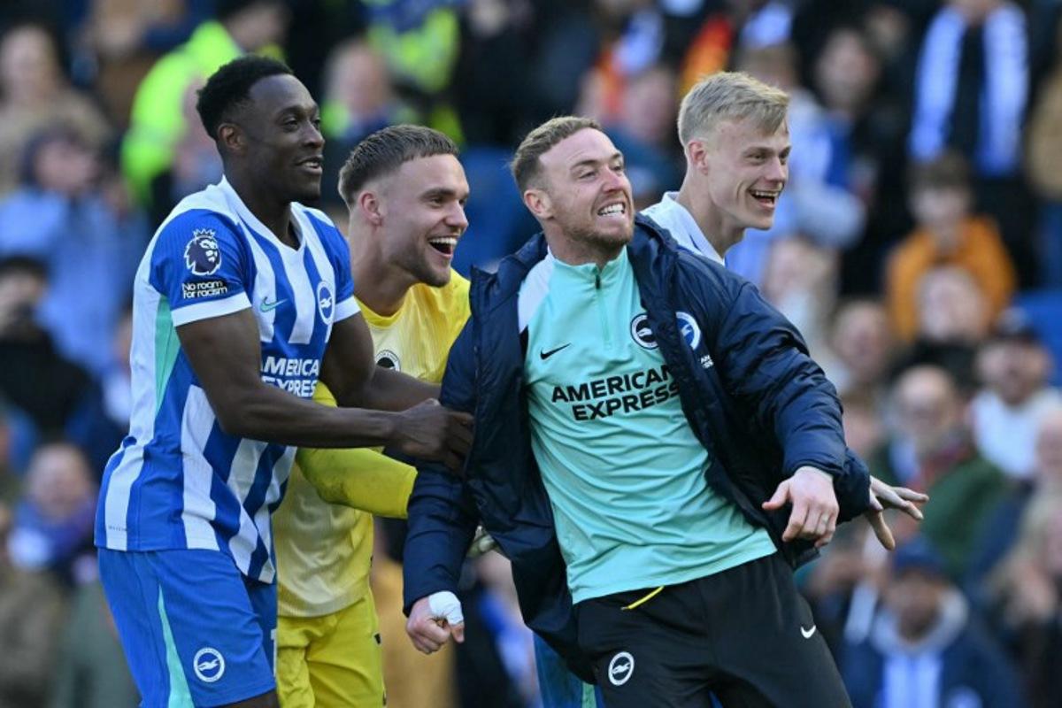 (L-R) Brighton's English striker #18 Danny Welbeck, Brighton's Dutch goalkeeper #01 Bart Verbruggen, Brighton's English goalkeeper #23 Jason Steele and Brighton's Dutch defender #06 Jan Paul van Hecke celebrate on the pitch after the English Premier League football match between Brighton and Hove Albion and Liverpool at the American Express Community Stadium in Brighton, southern England on March 21, 2026. Brighton won the game 2-1. Glyn KIRK / AFP