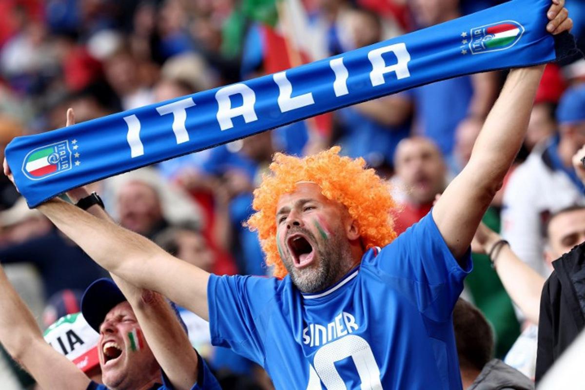 A fan of Italy cheers holding an Italian scarf prior the UEFA Euro 2024 Group B football match between Italy and Albania at the BVB Stadion in Dortmund, western Germany, on June 15, 2024. FRANCK FIFE / AFP