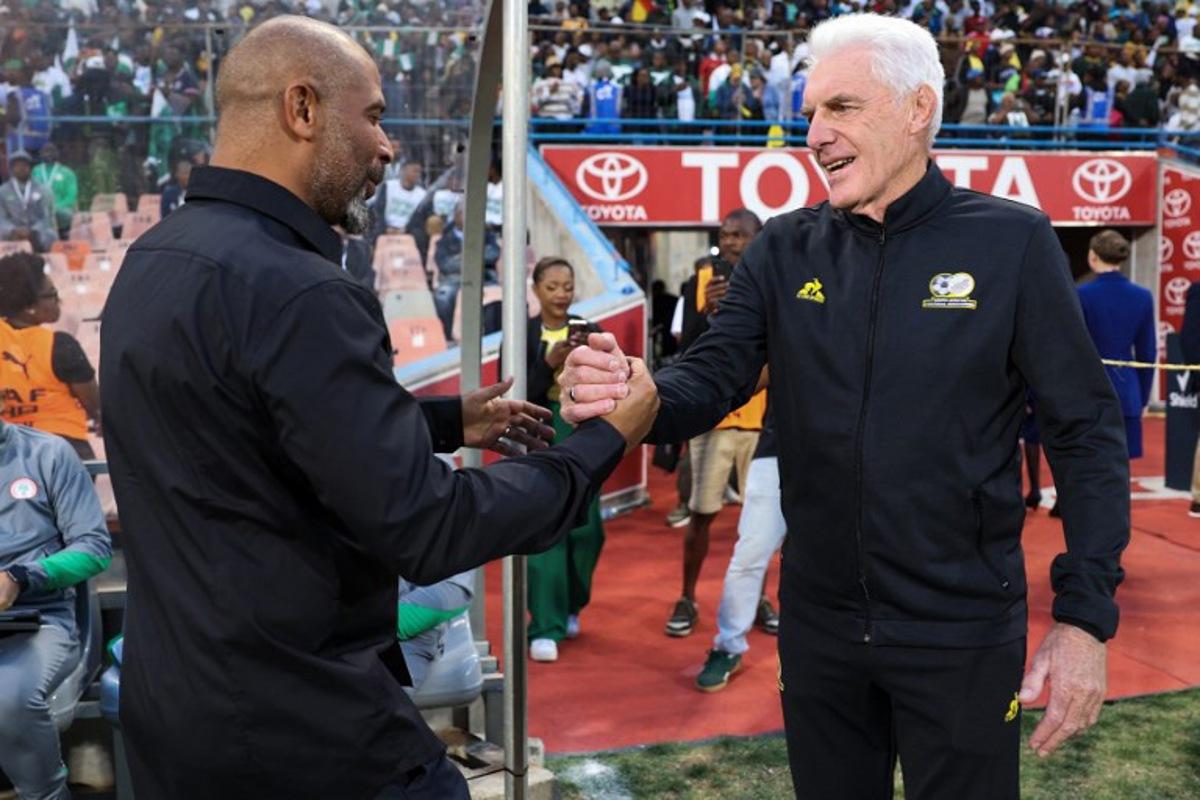 Nigeria's coach Eric Chelle (L) greets South Africa's Belgian coach Hugo Broos (R) ahead of the FIFA World Cup 2026 Africa qualifiers group C match between South Africa and Nigeria at the Free State Stadium in Bloemfontein on September 9, 2025. Phill Magakoe / AFP