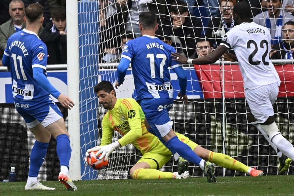Real Madrid's Belgian goalkeeper #01 Thibaut Courtois makes a save during the Spanish league football match between Deportivo Alaves and Real Madrid CF at the Mendizorroza stadium in Vitoria on April 13, 2025. ANDER GILLENEA / AFP