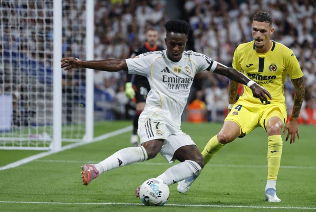 Real Madrid's Brazilian forward #07 Vinicius Junior and Villarreal's Spanish defender #04 Rafa Marin vie for the ball during the Spanish league football match between Real Madrid CF and Villarreal CF at the Santiago Bernabeu stadium in Madrid on October 4, 2025. Oscar DEL POZO / AFP