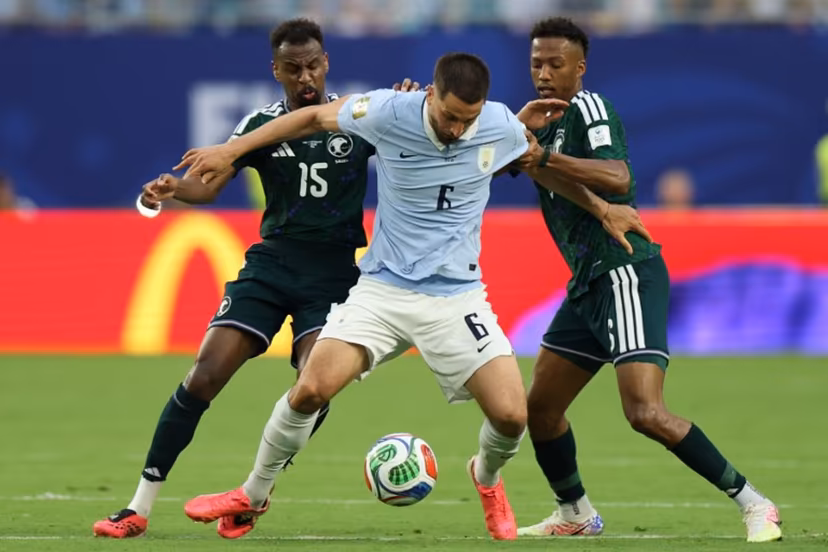 Saudi Arabia's midfielders #15 Abdullah Al-Khaibari, #06 Nasser Al-Dawsari (R) and Uruguay's midfielder #06 Rodrigo Bentancur fight for the ball during the 2026 World Cup Group H football match between Saudi Arabia and Uruguay at the Miami Stadium in Miami Gardens on June 15, 2026. PATRICIA DE MELO MOREIRA / AFP