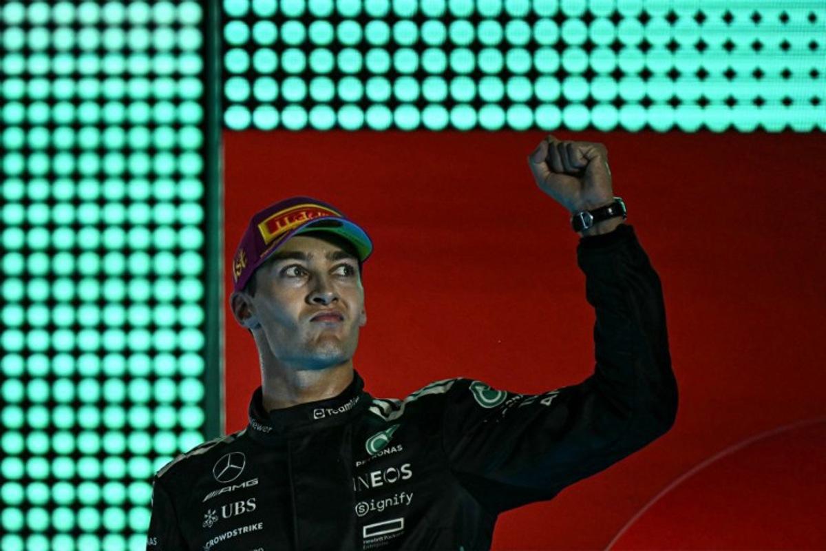First-placed Mercedes' British driver George Russell celebrates on the podium after the Formula One Singapore Grand Prix night race at the Marina Bay Street Circuit in Singapore on October 5, 2025. Lillian SUWANRUMPHA / AFP