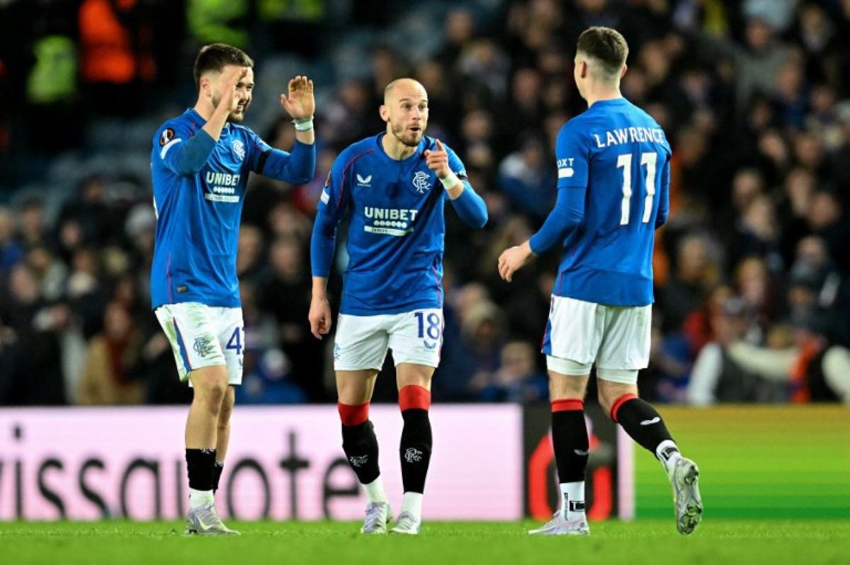 Rangers' Welsh striker #11 Tom Lawrence is congratulated by teammates Rangers' Scottish goalkeeper #41 Lewis Budinauckas (L) and Rangers' Czech midfielder #18 Vaclav Cerny after scoring a penalty during the UEFA Europa League second-leg round of 16 football match between Rangers and Fenerbahce SK at the Ibrox Stadium in Glasgow on March 13, 2025. ANDY BUCHANAN / AFP