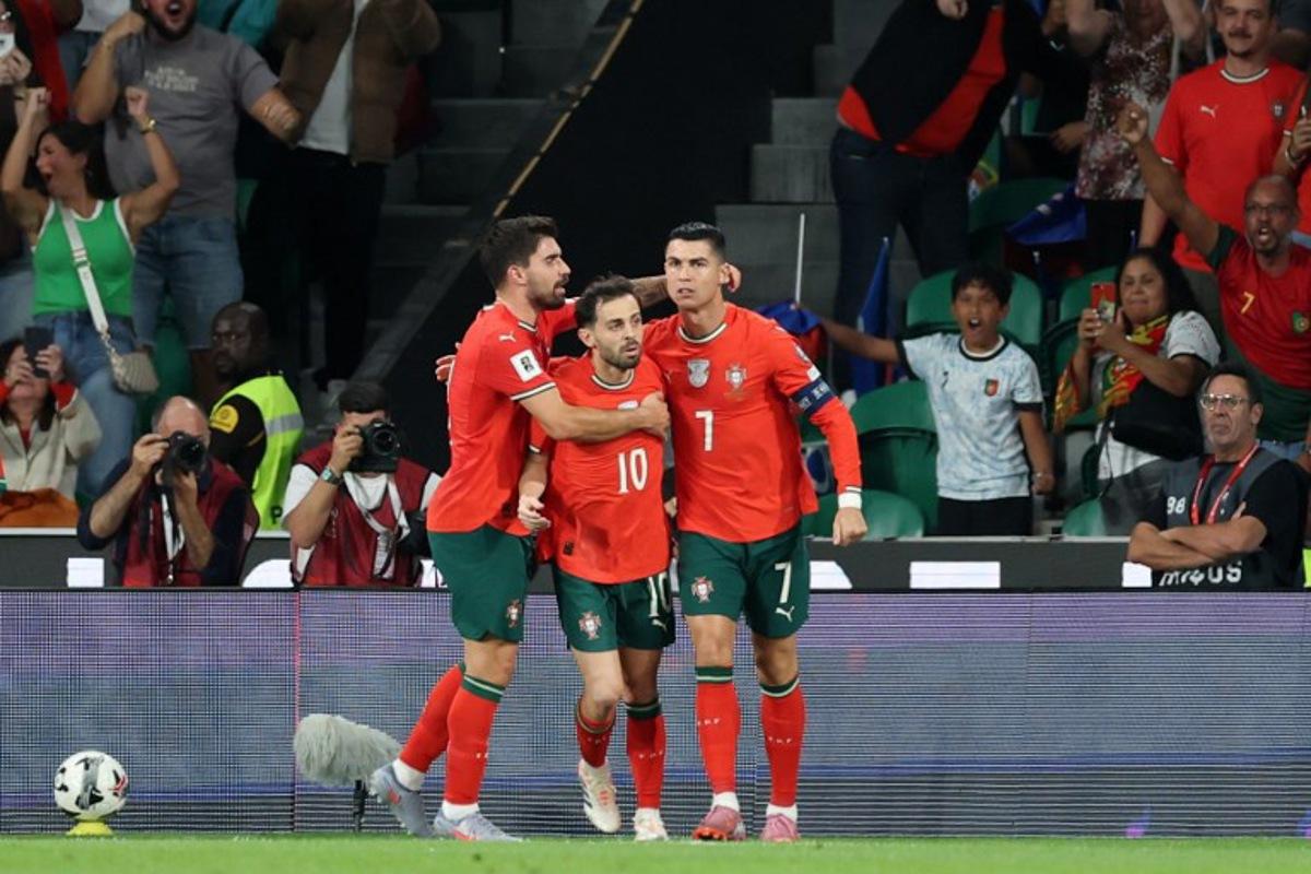 Portugal's forward #16 Cristiano Ronaldo celebrates with his teammates after scoring the equalising goal during the 2026 World Cup qualifiers Europe zone group F football match between Portugal and Hungary at Jose Alvalade stadium in Lisbon on October 14, 2025. PATRICIA DE MELO MOREIRA / AFP