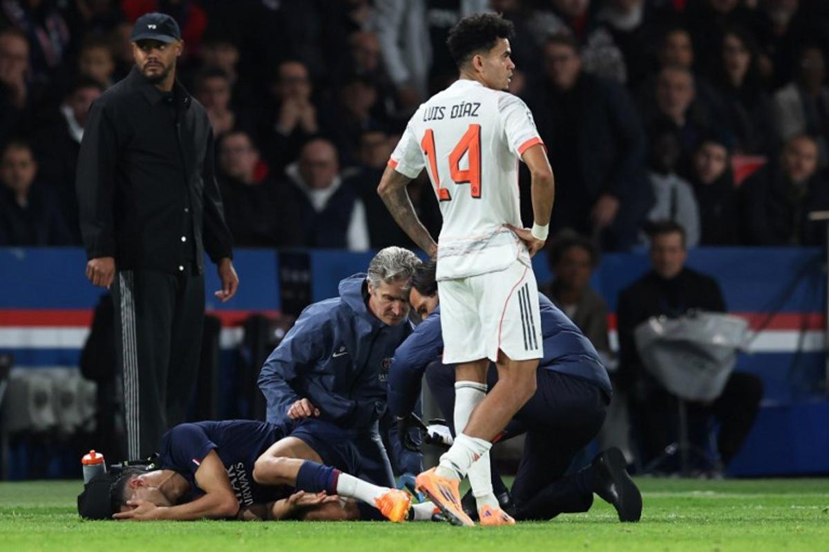 Paris Saint-Germain's Moroccan defender #02 Achraf Hakimi (L) reacts after picking up an injury, next Bayern Munich's Colombian forward #14 Luis Diaz (R), during the UEFA Champions League, league phase day 4, football match between Paris Saint-Germain (PSG) and FC Bayern Munich at the Parc des Princes in Paris, on November 4, 2025. Thomas SAMSON / AFP