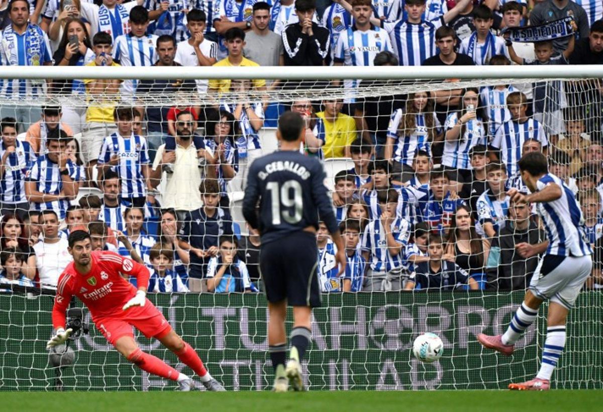 Real Sociedad's Spanish forward #10 Mikel Oiarzabal scores his team's first goal from the penalty spot in spite of Real Madrid's Belgian goalkeeper #01 Thibaut Courtois during the Spanish league football match between Real Sociedad and Real Madrid CF at Anoeta Stadium in San Sebastian on September 13, 2025. ANDER GILLENEA / AFP