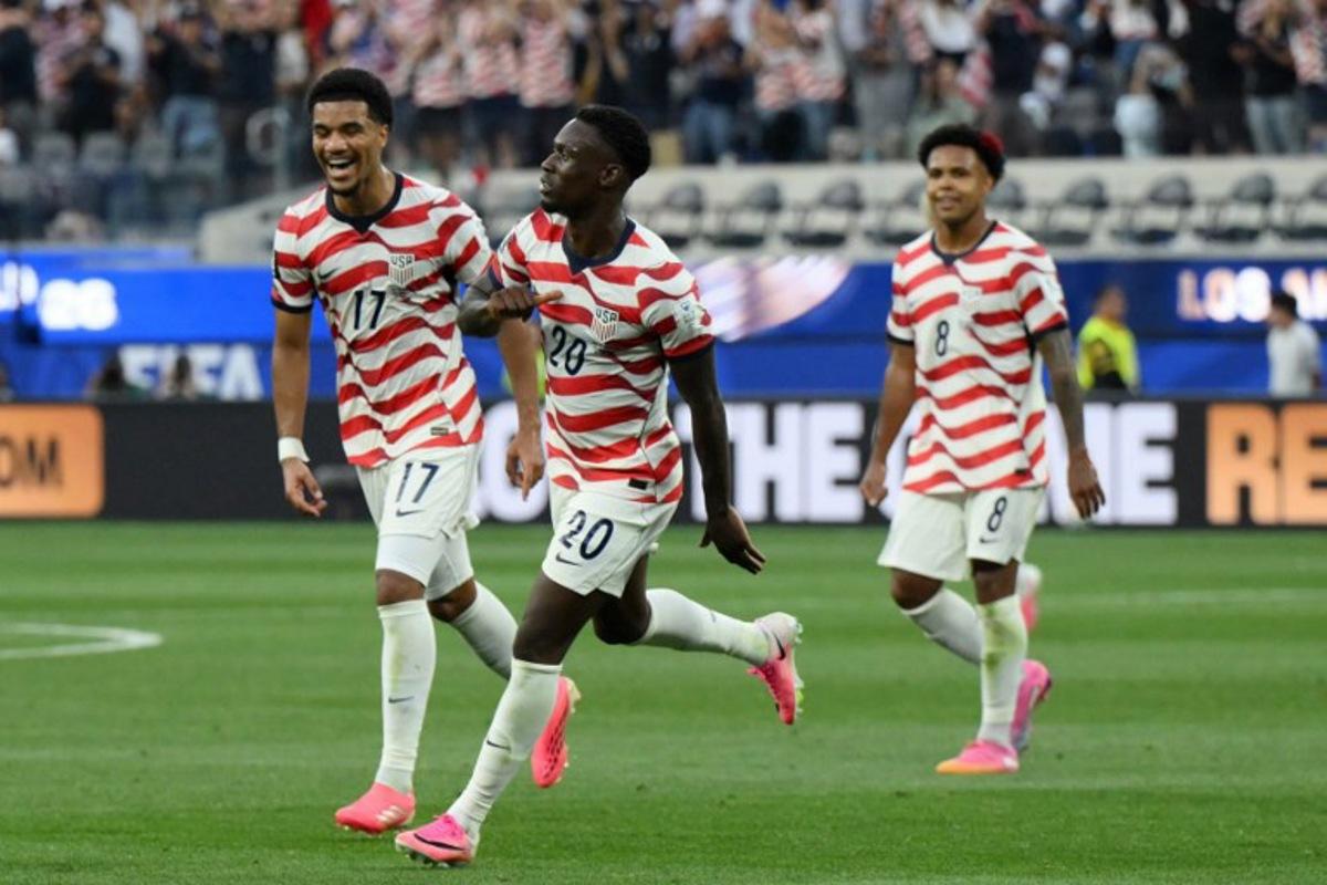 US forward #20 Folarin Balogun (C) celebrates scoring his team's third goal during the 2026 World Cup Group D football match between USA and Paraguay at the Los Angeles Stadium in Inglewood on June 12, 2026. Patrick T. Fallon / AFP