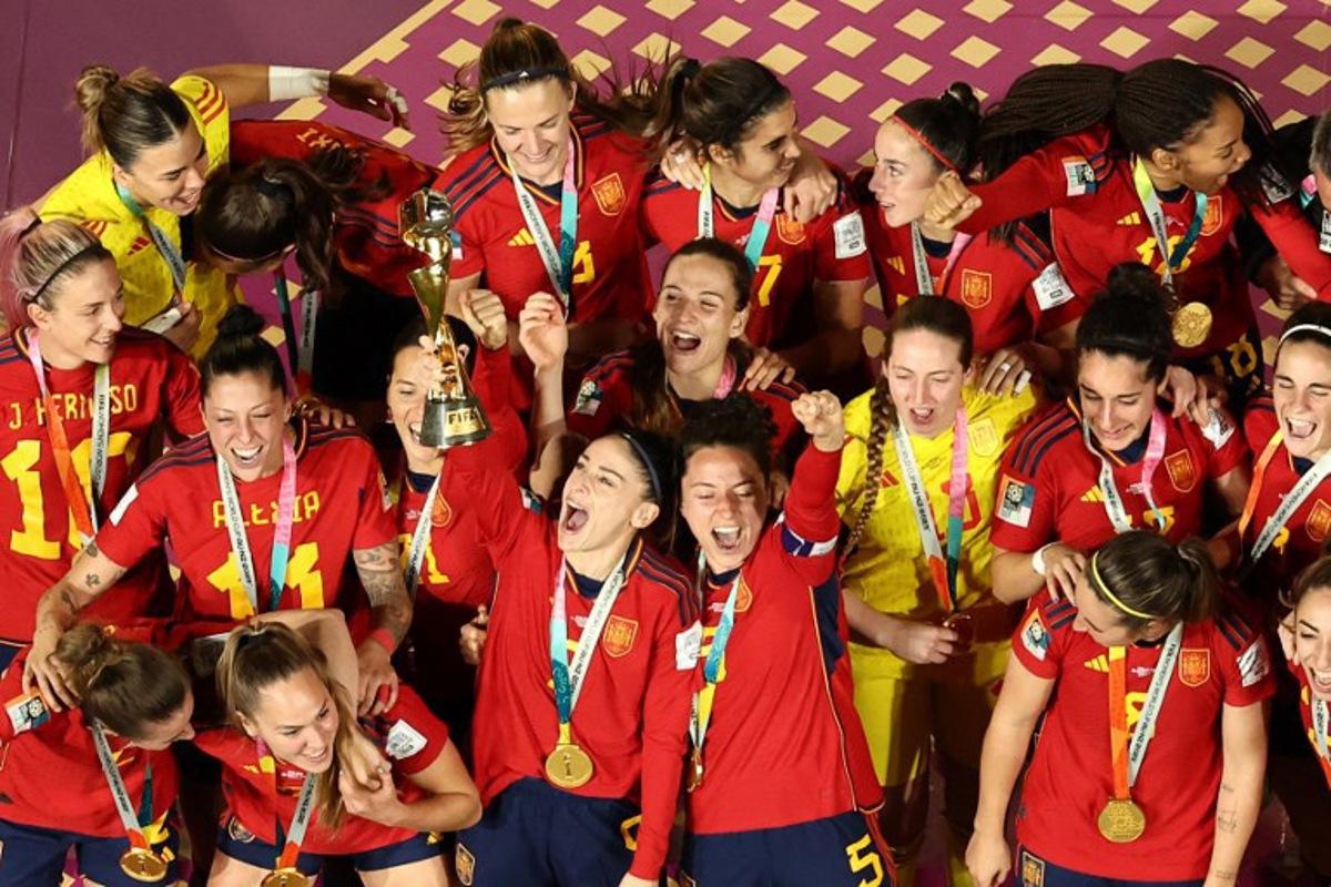 Spain's players celebrate with the trophy on the podium after winning the Australia and New Zealand 2023 Women's World Cup final football match between Spain and England at Stadium Australia in Sydney on August 20, 2023. DAVID GRAY / AFP