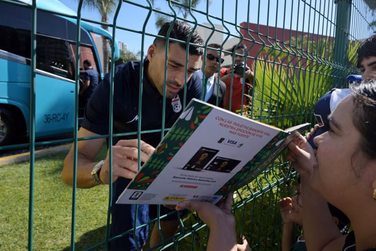 Iran's forward Mehdi Taremi signs autographs for a fan outside the Marriott Hotel before leaving for a training session in Tijuana, Mexico, on June 10, 2026, ahead of the 2026 FIFA World Cup football tournament. Guillermo Arias / AFP
