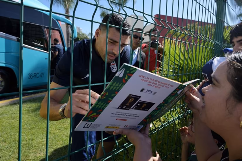 Iran's forward Mehdi Taremi signs autographs for a fan outside the Marriott Hotel before leaving for a training session in Tijuana, Mexico, on June 10, 2026, ahead of the 2026 FIFA World Cup football tournament. Guillermo Arias / AFP