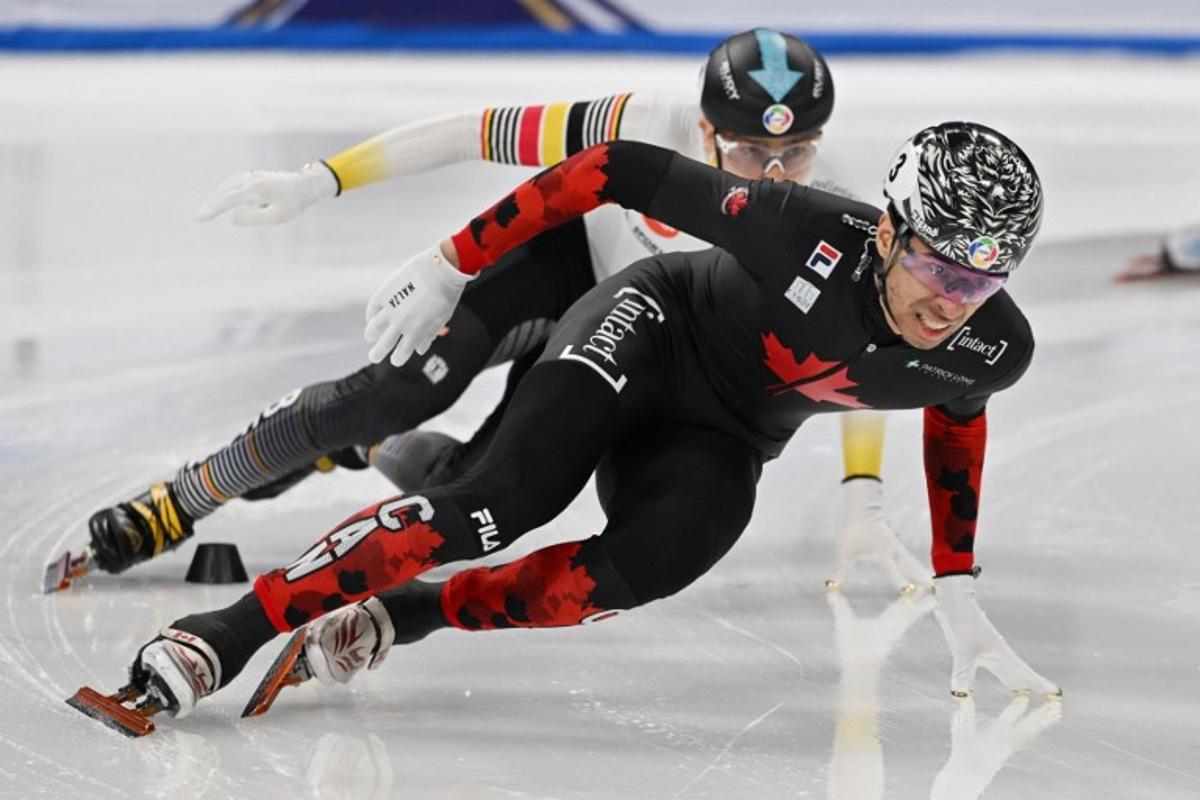 Canada's William Dandjinou (front) leads Belgium's Stijn Desmet in the men's 1500 meter final at the ISU World Short Track Championships in Beijing on March 15, 2025. GREG BAKER / AFP