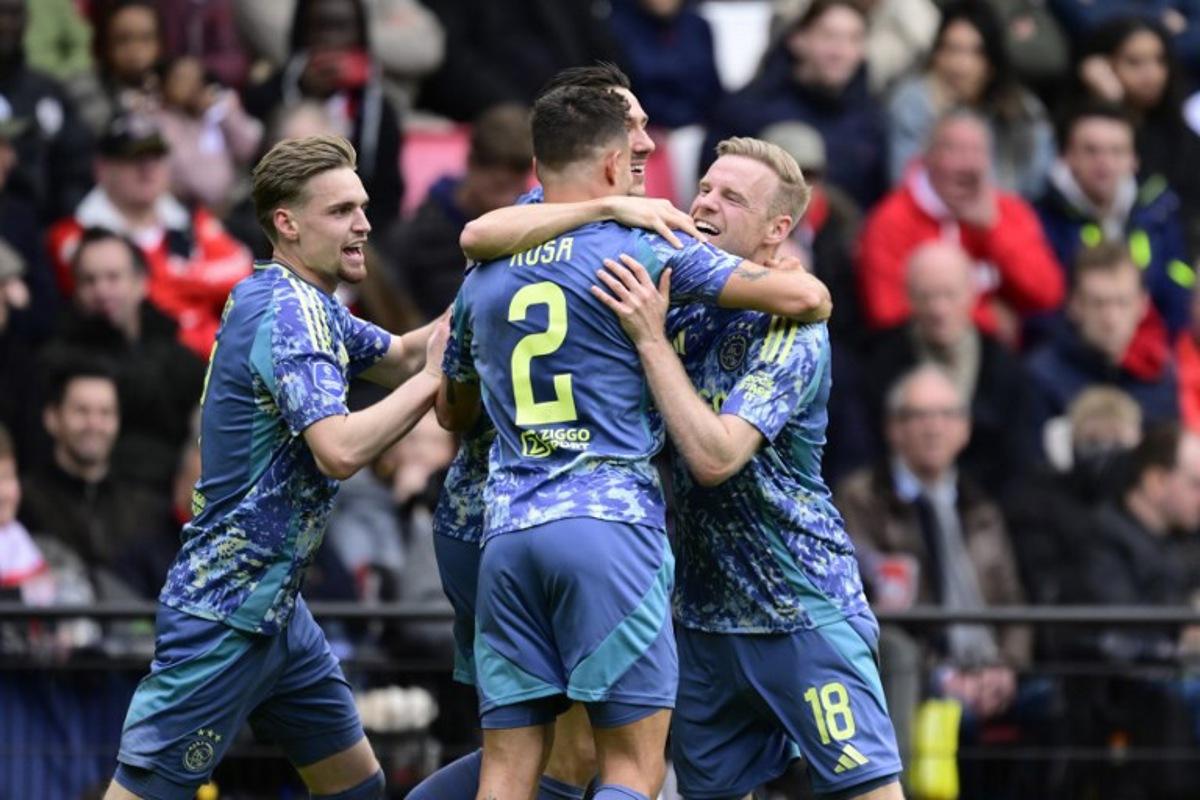 Ajax's Dutch midfielder #18 Davy Klaassen (R) celebrates with teammates Ajax's Dutch midfielder #08 Kenneth Taylor (L) and Ajax's Brazilian defender #02 Luca Rosa (C) after scoring the opening goal during the Dutch Eredivisie fooball match between PSV Eindhoven and Ajax Amsterdam at the Phillips Stadium in Eindhoven on March 30, 2025. Olaf Kraak / ANP / AFP