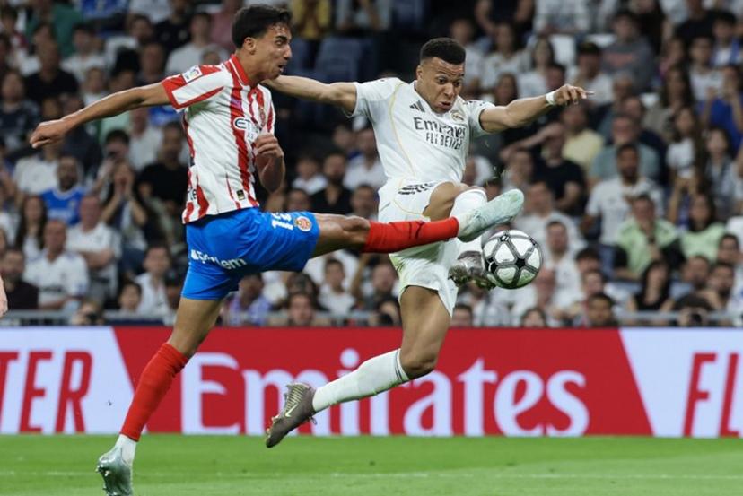 Real Madrid's French forward #10 Kylian Mbappe (R) is challenged by Girona's Brazilian defender #12 Vitor Reis during the Spanish league football match between Real Madrid CF and Girona FC at the Santiago Bernabeu stadium in Madrid on April 10, 2026. Thomas COEX / AFP