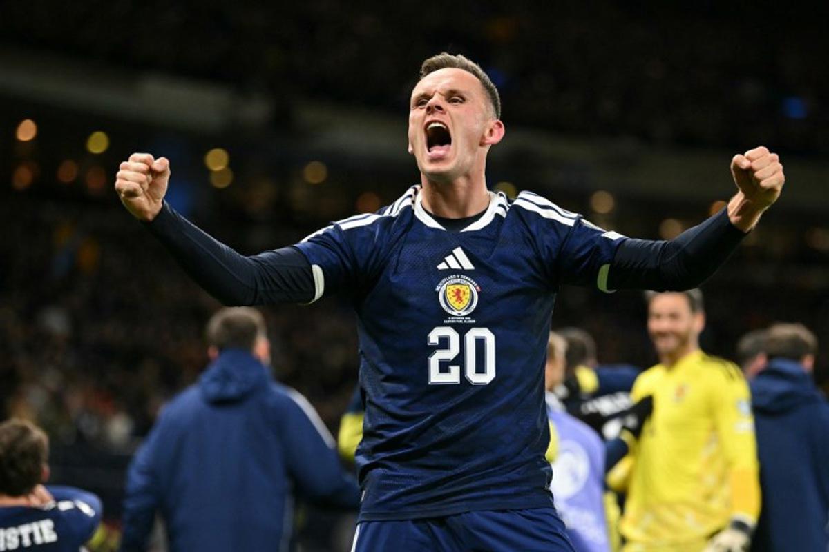 Scotland's striker #20 Lawrence Shankland celebrates on the pitch after the FIFA World Cup 2026 European qualification football match between Scotland and Denmark at Hampden Park in Glasgow on November 18, 2025. Scotland scored two dramatic stoppage-time goals to beat 10-man Denmark 4-2 on Tuesday and reach the World Cup for the first time since 1998. ANDY BUCHANAN / AFP