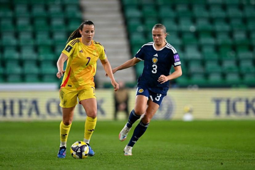 Belgium's forward #07 Hannah Eurlings runs with the ball from Scotland's Defender #03 Amy Muir during the Women's FIFA world cup league B, group 4, qualifier football match between Scotland and Belgium at Easter Road, in Edinburgh, Scotland, on April 14, 2026. ANDY BUCHANAN / AFP