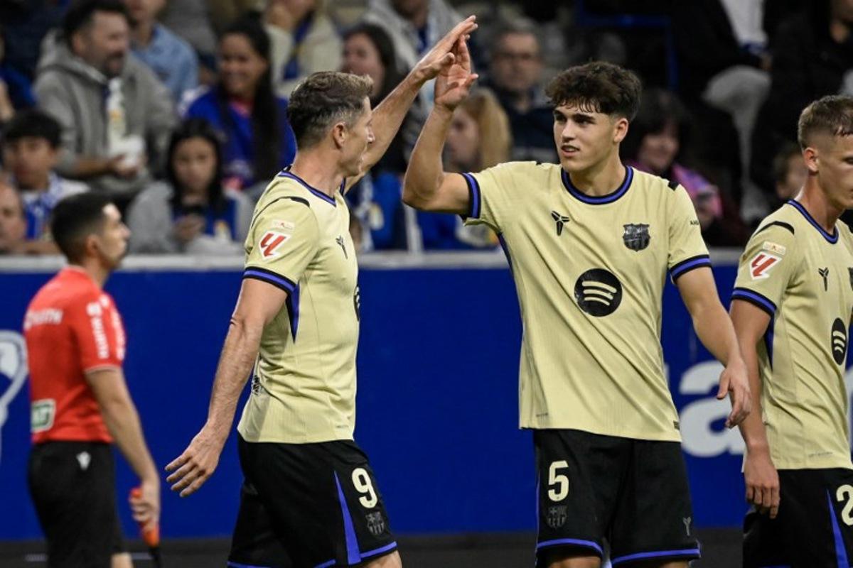 Barcelona's Polish forward #09 Robert Lewandowski (L) celebrates with teammate Barcelona's Spanish defender #05 Pau Cubarsi after scoring their second goal during the Spanish league football match between Real Oviedo and FC Barcelona at the Carlos Tartiere stadium in Oviedo on September 25, 2025. Miguel RIOPA / AFP