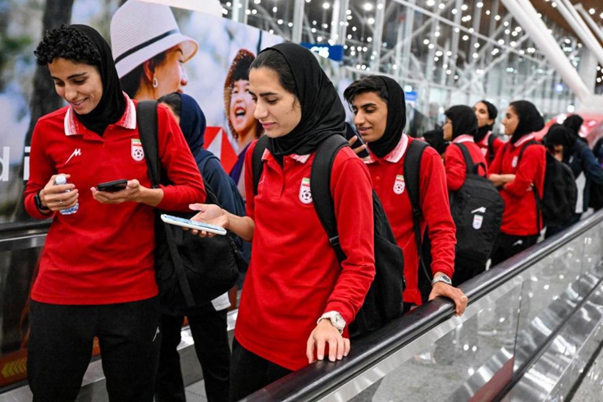 Members of Iran's women's football team walk as they arrive at the Kuala Lumpur International Airport after taking part in the AFC Women's Asian Cup Australia 2026 tournament in Australia, in Sepang on March 11, 2026. At least five players from Iran's visiting women's football team claimed asylum in Australia on on March 10, seeking protection after they were branded "traitors" at home for refusing to sing the national anthem. Mohd RASFAN / AFP