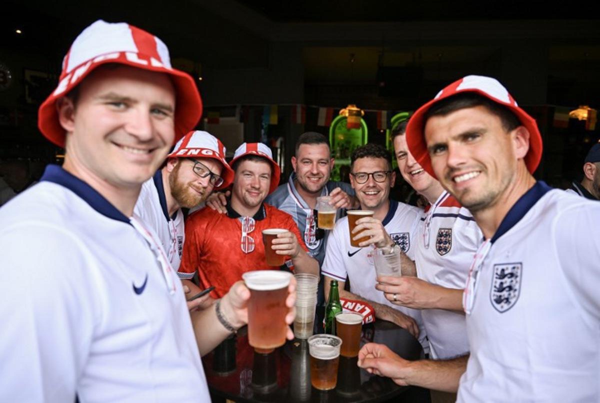 England supporters pose with beer glasses in the area of the main station of Frankfurt am Main on June 20, 2024, before the UEFA Euro 2024 Group C football match between Denmark and England. Kirill KUDRYAVTSEV / AFP