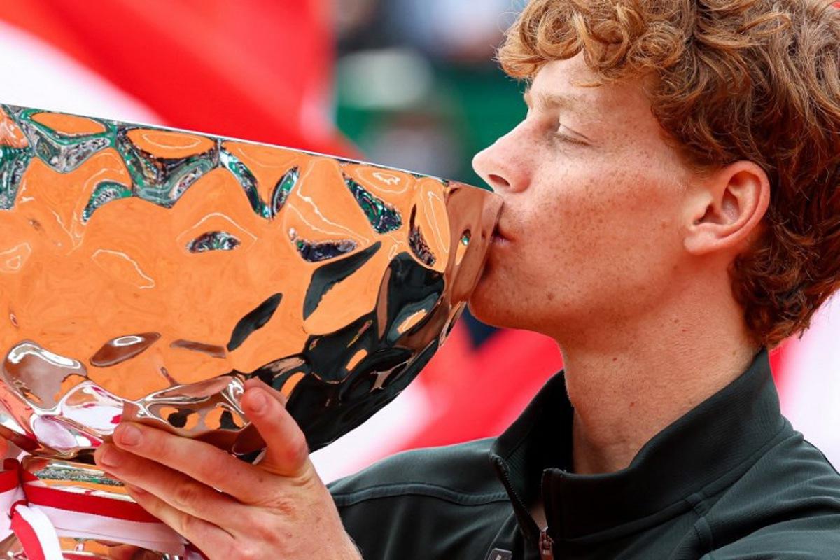 Italy's Jannik Sinner kisses the trophy as he celebrates on the podium after winning the Monte Carlo ATP Masters Series Tournament final tennis match against Spain's Carlos Alcaraz on Court Rainier III at the Monte-Carlo Country Club in Roquebrune-Cap-Martin, south-eastern France on April 12, 2026. Valery HACHE / AFP