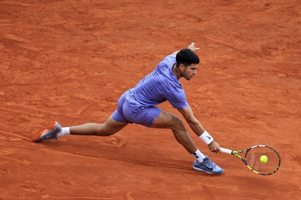 Spain's Carlos Alcaraz plays a backhand return to Spain's Alejandro Davidovich Fokina during the Monte Carlo ATP Masters Series Tournament semi-final tennis match at the Monte Carlo Country Club in Roquebrune-Cap-Martin on April 12, 2025. Valery HACHE / AFP