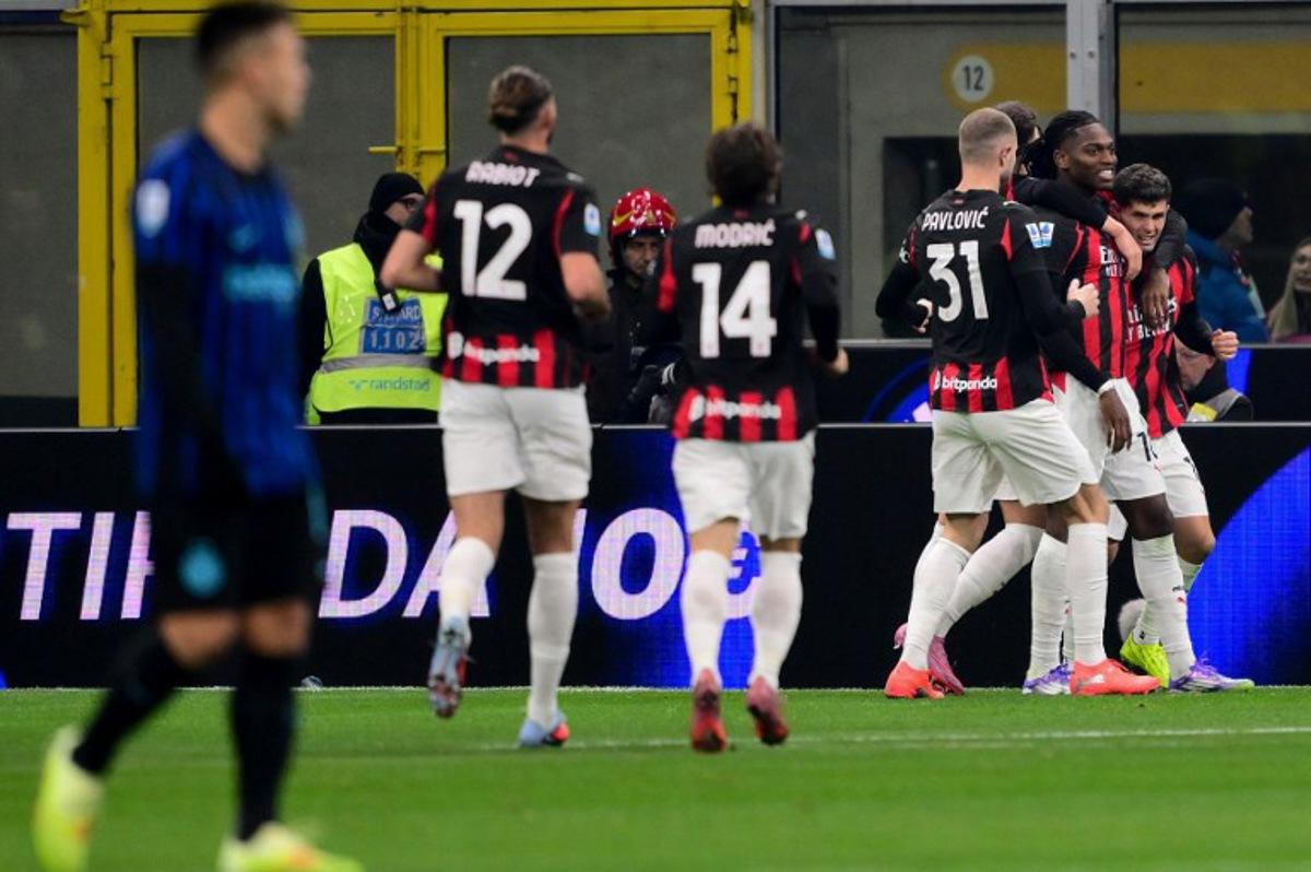 AC Milan's US forward #11 Christian Pulisic (R) celebrates with teammates after scoring his team's first goal during the Italian Serie A football match between Inter Milan and AC Milan at San Siro stadium in Milan, northern Italy, on November 23, 2025. Marco BERTORELLO / AFP