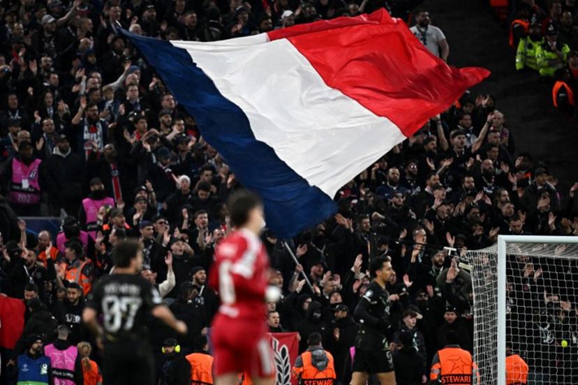The French flag is flown in the stands by PSG fans during the UEFA Champions League quarter final, second-leg football match between Liverpool and Paris Saint-Germain at Anfield in Liverpool, north west England on April 14, 2026. Paul ELLIS / AFP
