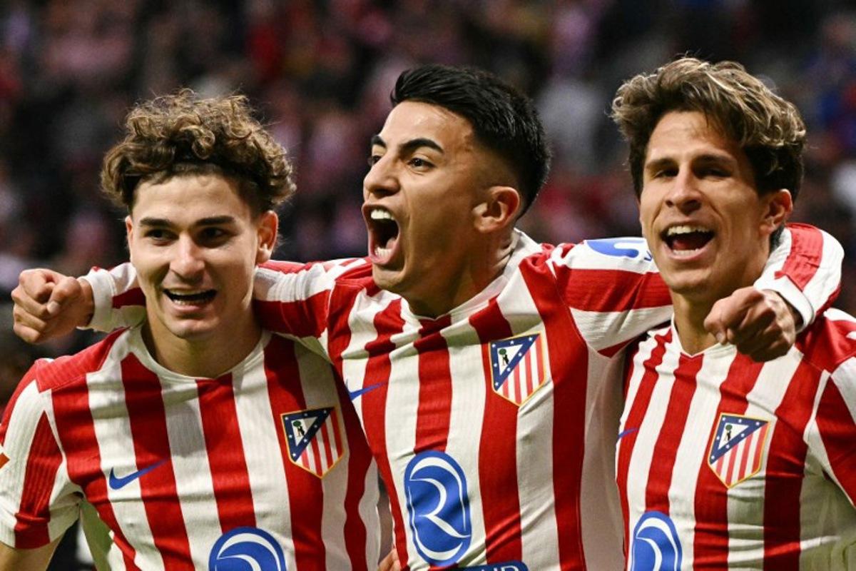 Atletico Madrid's Argentine midfielder #11 Thiago Almada (C) celebrates scoring his team's second goal with Atletico Madrid's Argentine forward #19 Julian Alvarez (L) and Atletico Madrid's Argentine forward #20 Giuliano Simeone during the Spanish League football match between Club Atletico de Madrid and Sevilla FC at Metropolitano Stadium in Madrid on November 1, 2025. JAVIER SORIANO / AFP