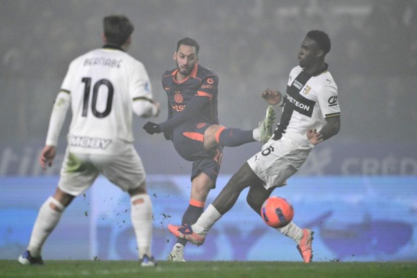 Inter Milan's Turkish midfielder #20 Hakan Calhanoglu kicks the ball next to Parma's Belgian midfielder #16 Mandela Keita during the Italian Serie A football match between Parma and Inter Milan at the Ennio Tardini stadium in Parma on January 7, 2026. Marco BERTORELLO / AFP