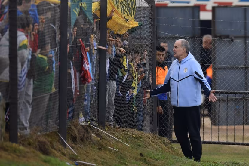 Uruguay's fnational football team coach, Argentinian Marcelo Bielsa, greets fans during a farewell activity with children ahead of the departure of the squad for the FIFA World Cup 2026, at the Tito Lopez Lopez stadium in Pando, Canelones department, Uruguay on June 5, 2026. Dante FERNANDEZ / AFP