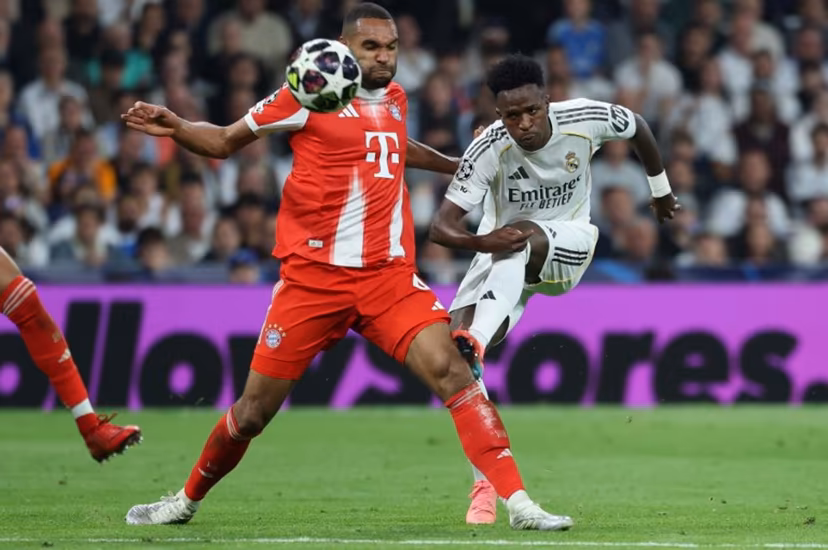 Real Madrid's Brazilian forward #07 Vinicius Junior (R) kicks past Bayern Munich's German defender #04 Jonathan Tah during the UEFA Champions League quarter final first leg football match between Real Madrid CF and FC Bayern Munich at Santiago Bernabeu Stadium in Madrid on April 7, 2026. Thomas COEX / AFP