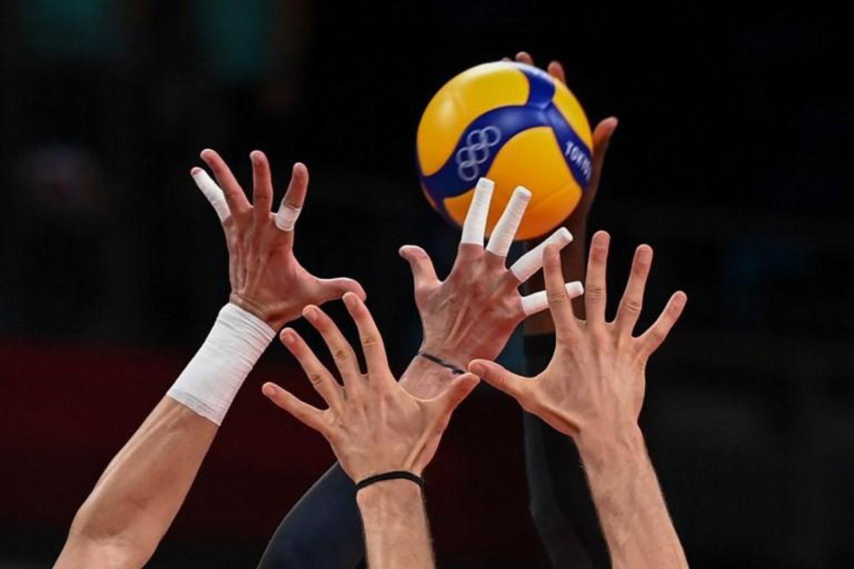 (L-R) Italy's Osmany Juantorena and Italy's Matteo Piano block a shot by Italy's Massimo Colaci in the men's preliminary round pool A volleyball match between Italy and Canada during the Tokyo 2020 Olympic Games at Ariake Arena in Tokyo on July 24, 2021. YURI CORTEZ / AFP