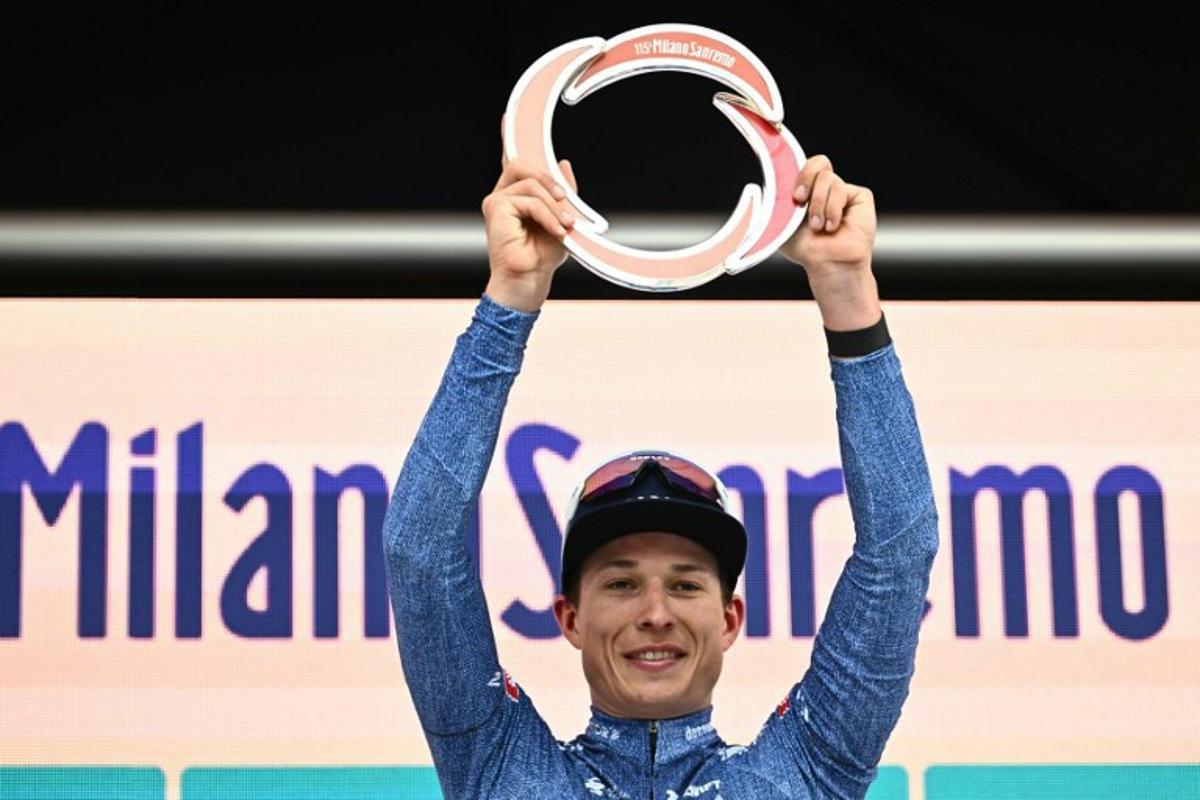 Alpecin-Deceuninck's Belgian rider Jasper Philipsen celebrates with the trophy on the podium after winning the 115th Milan-SanRemo one-day classic cycling race, between Pavia and SanRemo, on March 16, 2024. Marco BERTORELLO / AFP